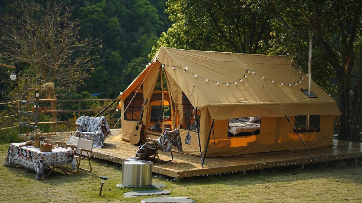 Panda Large glamping tent is laid out on a wooden platform, with tables, chairs and personal belongings of vacationers in front of it